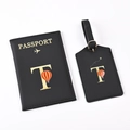 Detail of black passport holder and luggage tag set with golden letter T and balloon - Black Letter T