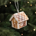 Brown gingerbread house Christmas ornament with white glitter patterns hanging on tree - Grid House