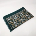 Close-up of dark green cashmere-feel shawl featuring golden floral embroidery and tassels - Green