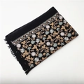 Close-up of black cashmere-like shawl featuring intricate floral embroidery and fringe - Black
