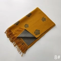 Detail of soft yellow cashmere-style scarf featuring camellia pattern and grey fringe - Yellow