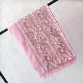 Close-up of pink cashmere shawl featuring golden paisley embroidery and elegant fringe details - Pink