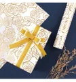 Detail of luxury white gift wrapping paper with elegant gold rose line art and golden ribbon - Rose
