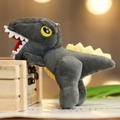 Dark grey plush dinosaur keychain featuring yellow spines on a wooden box edge - Approx. 14cm / Gray