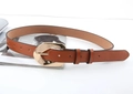 Close-up of brown leather belt with an irregular oval golden buckle on a magazine - Khaki