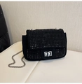 Macro view of black suede evening bag with glittering rhinestones and silver turn lock - Black