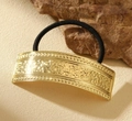 Dettaglio dell'elastico per capelli nero con ciondolo rettangolare in metallo dorato inciso - Stile Rettangolo in Rilievo Vintage Oro
