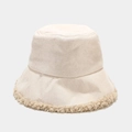 Dettaglio del cappello a secchiello invernale in tessuto beige con bordo in lana d'agnello - Regolabile / Bianco