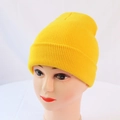 Detail of bright yellow knitted beanie showing fine ribbed texture on a model head - One Size / Yellow
