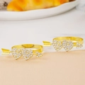 Detailed view of two gold heart-shaped napkin rings with crystal rhinestones and arrows - Gold Arrow Two Hearts