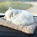 Close-up of fluffy white realistic sleeping cat toy resting on a brown plush cushion - Large Pure White Cat