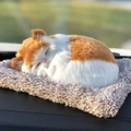 Detailed view of a realistic orange and white plush sleeping cat on a cozy beige mat - Large Orange and White Spotted Cat