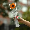 Close-up of handmade crochet sunflower bouquet in elegant gift wrapping with a red tag - Sunflower