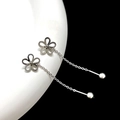 Macro detail of silver flower tassel earring with hollow petals on ceramic base - Steel Hollow Flower Ear Chain