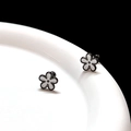 Macro view of minimalist black and white daisy floral earrings in high-grade titanium steel - White Black Flower Ear Bone Stud (Single)