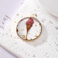 Detail of round resin pendant with red dried flowers, gold foil, and brass frame - Flower Bud With Gold Foil