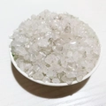 Macro shot of natural clear crystal stone chips in a white dish on wood background - White Crystal