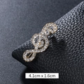 Elegant music note brooch in gold plating with sparkling white crystals, 4.1cm x 1.6cm - Pave-Set Treble Clef Gold (XD9421)