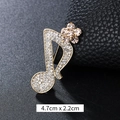 Luxurious eighth note brooch in gold finish with sparkling crystals and a flower detail - Champagne Flower Music Note Gold (XD9423)