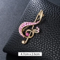 Spilla a chiave di violino dorata con cristalli rosa su ecopelle nera testurizzata - Chiave di Violino Strass Rosa Grande Oro (XD9426)