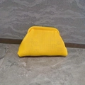 Macro detail of bright yellow knitted cloud clutch bag showing soft woven texture - Yellow