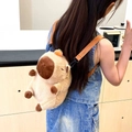 Close-up of a child wearing the Capybara plush backpack with adjustable straps and orange detail - Small Light Brown / Small 25cm