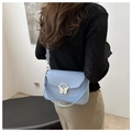 Détail du sac bandoulière bleu clair avec un fermoir métallique en forme de papillon argenté - Bleu