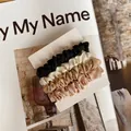Detailed view of four satin scrunchies in black, cream, coffee, and pink on a display card - Four-Piece Set / Type B Black White Gold Pink