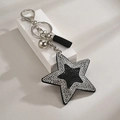 Detail of a black sequin star keychain with sparkling rhinestones and a black fringe tassel - Silver Black