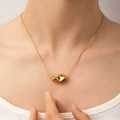 Macro view of gold minimalist twisted geometric pendant on a delicate snake chain - Twisted Geometric Style (N0205)