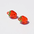 Macro detail of red acrylic strawberry charms for DIY jewelry making with realistic texture - Red Strawberry