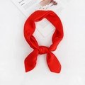 Detail view of red square silk scarf tied on a white surface with minimalist lifestyle props - Red