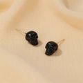 Detailed close-up of matte black gothic skull stud earrings with golden metal posts - Skull Stud Earrings (05 Matte Black 2902) / Matte Black