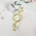 Macro shot of gold floral crystal watch with white dial and Arabic numerals - Gold Case White Dial
