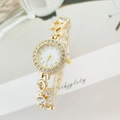 Macro detail of gold watch band featuring crystal-encrusted swan links and polished finish - Gold