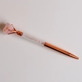 Detail van roségouden metalen pen met roze ruwe kristalsteen en edelsteen vulling - Rozenkwarts