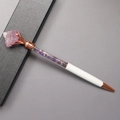 Detail van een roségouden balpen met roze kristallen top en paarse steenvulling - Amethist