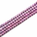 Macro detail of natural purple stone beads with matte porous texture for DIY jewelry - Pink