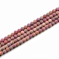 Macro detail of 10mm matte purple natural stone beads for DIY jewelry making and crafts - Red