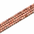 Macro shot of 10mm pink natural stone beads with unique textures for DIY jewelry making - Rose Red