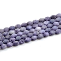 Macro shot of purple oval geode agate beads showing natural lava textures for DIY jewelry - Violet