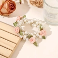 Detailed view of white pearls and pink fabric roses on an elastic hair tie band - Pink Flower