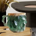 Detail of green crystal mineral coffee mug with gold rim on a rustic wooden table - Dark Green