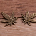 Bronze alloy maple leaf charms with detailed vein textures on a natural wooden background - 22x25mm / Small Antique Bronze