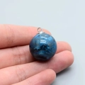 Macro-opname van een handbediende blauwe melkweg hiel hanger van hars met metalen ring - Donkerblauw
