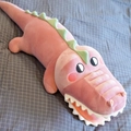 Close-up of a soft pink and green plush crocodile pillow on a grey checkered bed sheet - 35 cm / Pink