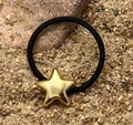 Dettaglio dell'elastico per capelli nero con ciondolo a stella dorata lucida - Stella Oro