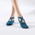 Blue cotton yoga socks with cross-strap design and non-slip soles on feet - One Size / Peacock Blue