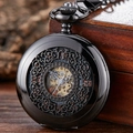 Detailed close-up of a vintage black hollow mechanical pocket watch on a mahogany box - Black