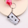 Macro shot of silver metal cassette tape keychain with white mother-of-pearl inlay - White